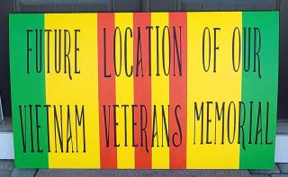text future location of our vietnam veterans' memorial on painted wood sign
