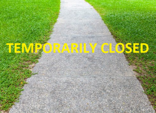 walking path with temporarily closed written across in yellow letters
