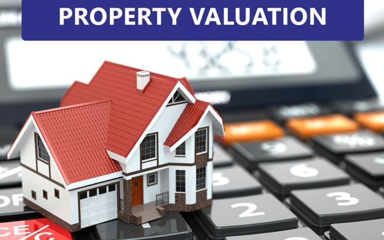 house placed on keyboard titled property valuation